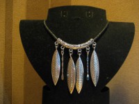 Collar de cordón y aplicaciones en forma de hojas en metal plateado.