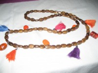 Collar en abalorios de madera, vidrio y cerámica con borlas de colores.