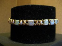 Pulsera con piedras cuadradas en blanco con dupis dorados